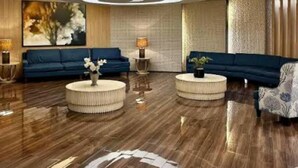 A modern living room with two sofas, round coffee tables, and a large abstract painting on the wall. - Dainty Pasay City Apartment for Rent - Entire House Front of Mall of Asia (Pasay)
