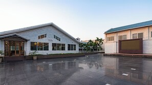 Ein modernes Gebäude mit Glasfassade, flachem Dach und großem Eingang.