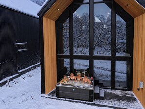 A modern building with large windows and a hot tub area. - The Lofts @ Frost Fire- Cabin A (Walhalla)