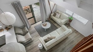 Moderni olohuone, jossa on sohva, sohvapöytä ja ruokailutila.