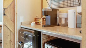 A compact kitchenette with a Galanz refrigerator, a Keurig coffee maker, and a paper towel dispenser. - GLAT Austin (Bastrop)