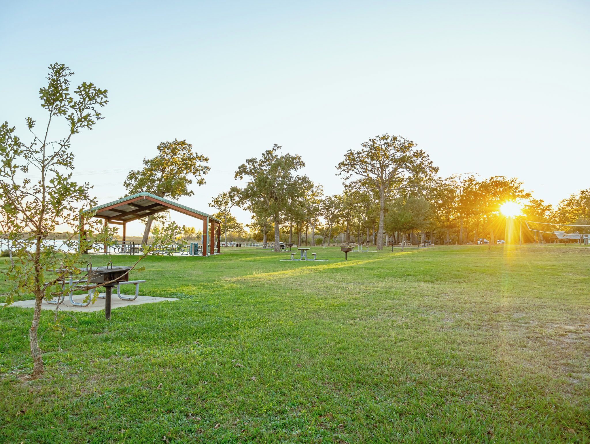 Een park met picknicktafels, een overdekte feesttent en een speeltuin.