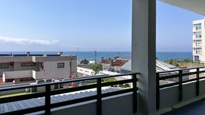 Ein Balkon mit Blick auf das Meer und Gebäude.