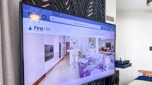 Pagina web che mostra un interno moderno di un hotel con angolo cottura, zona pranzo e soggiorno.