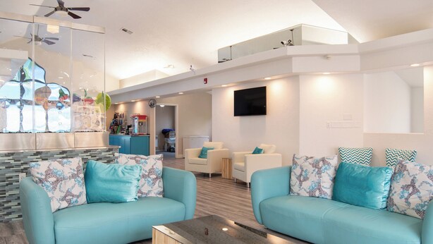 A modern living area with two light blue sofas, a coffee table, and a TV mounted on the wall. - Desert Views Retreat, 8 Bedrooms, Sleeps 24, Community Amenities (St. George)