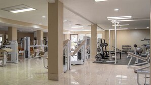 A spacious gym with various exercise machines, a weight rack, and a mirrored wall. - Desert Views Retreat, 8 Bedrooms, Sleeps 24, Community Amenities (St. George)