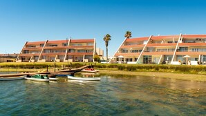 Un hotel sul lungomare con numerosi balconi, acque cristalline e un pontile con barche.