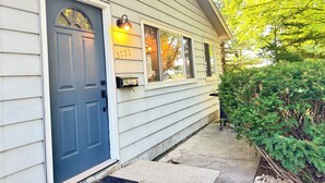 Une maison avec une porte d’entrée bleu foncé, une boîte aux lettres et le numéro « 3733 » peint sur le mur.