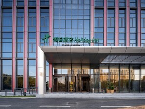 A modern building with a glass facade and a sign for 'Holiday Inn'. - Holiday Inn Beijing Daxing Centre By Ihg (Daxing)