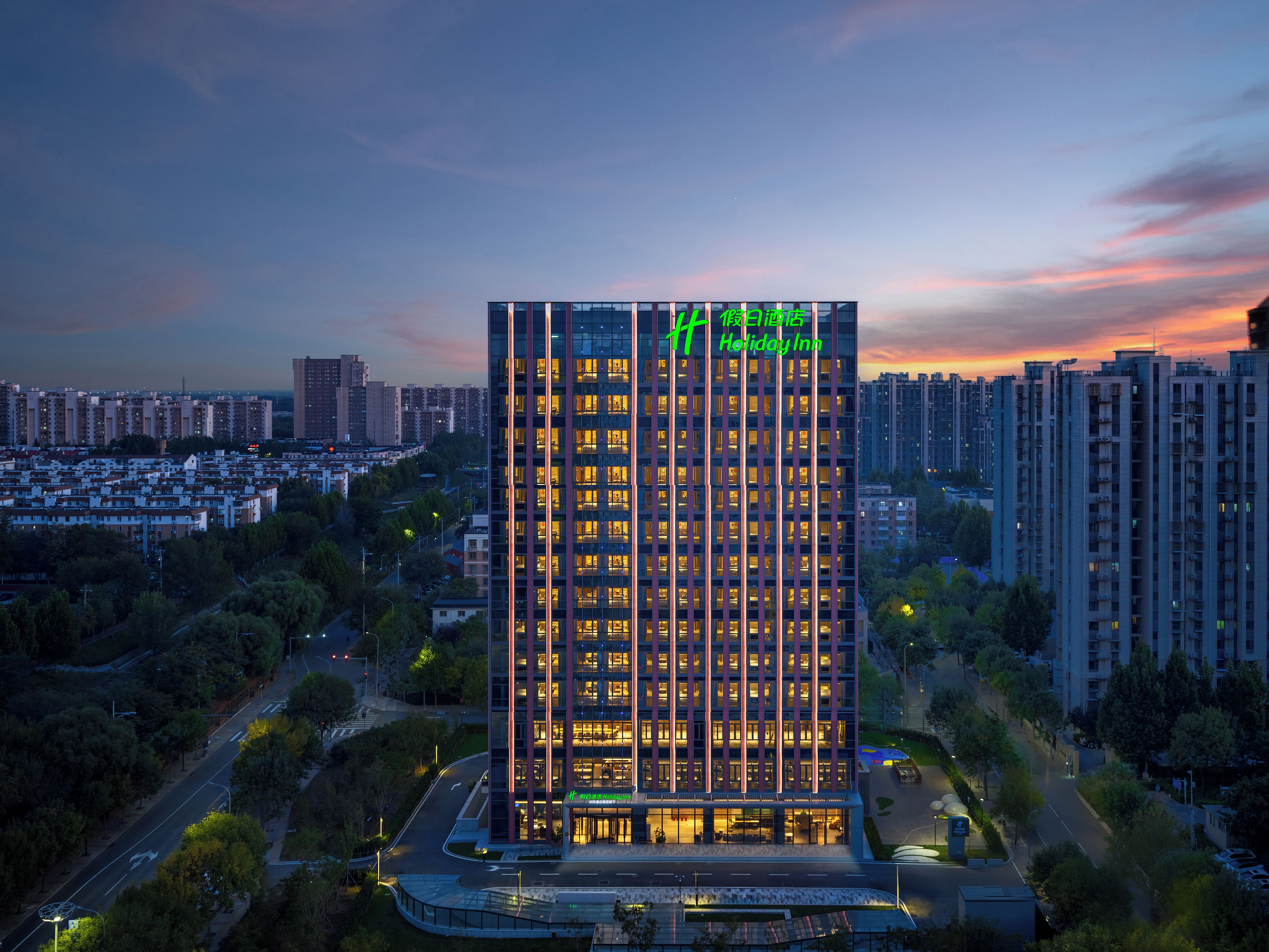 A high-rise hotel with a modern design, featuring a prominent vertical structure and illuminated windows.