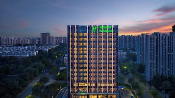A high-rise hotel with a modern design, featuring a prominent vertical structure and illuminated windows.