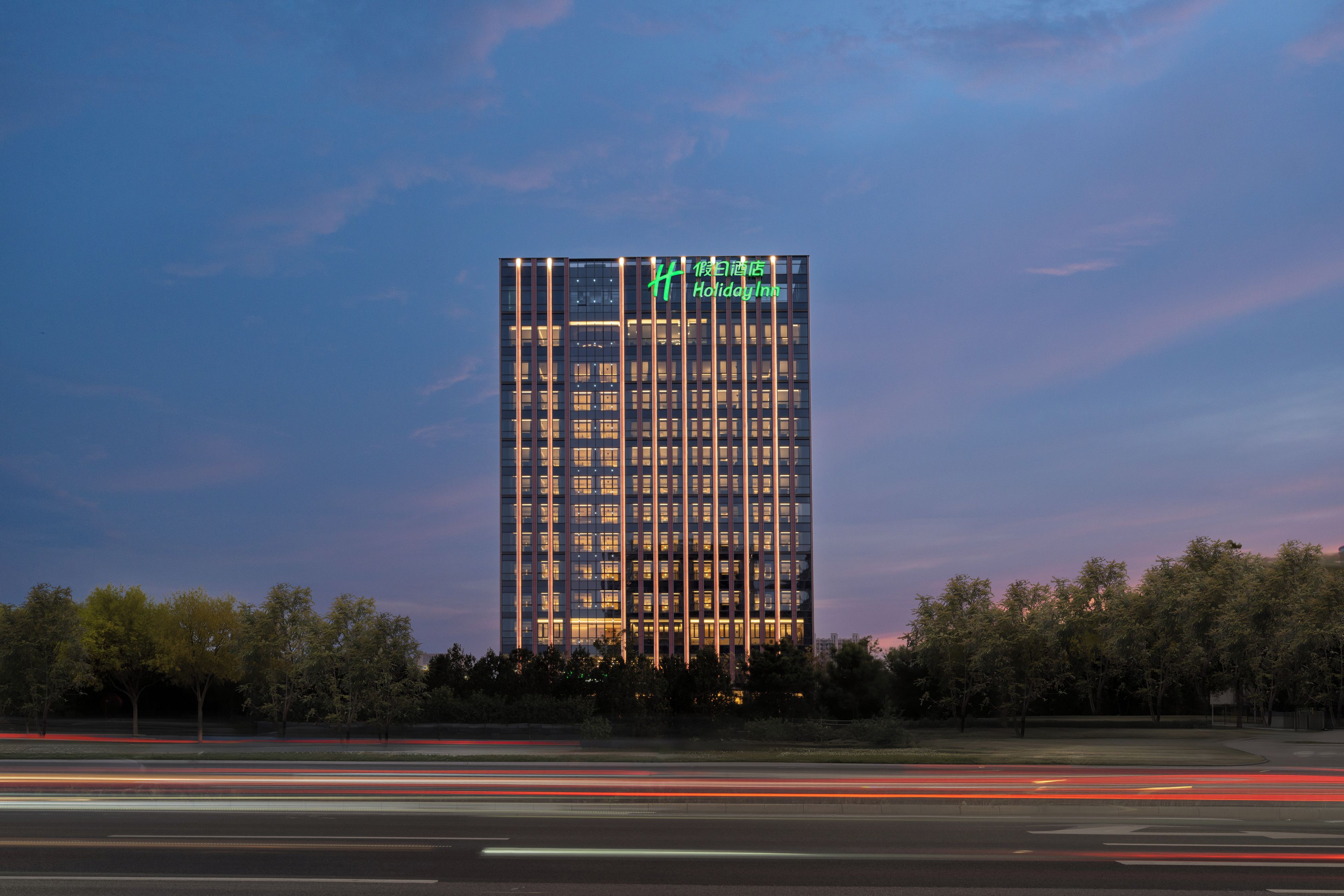 Un grand immeuble d’hôtel au design moderne, avec un logo bien visible sur sa façade.