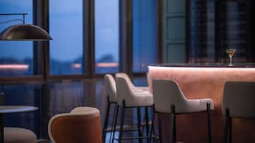 A bar area with a bar counter, stools, and a martini glass.