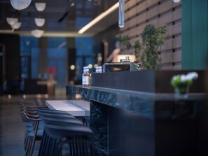 A modern interior with a marble counter, bar stools, and a potted plant. - Holiday Inn Beijing Daxing Centre By Ihg (Daxing)