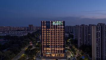 A high-rise Holiday Inn with a modern design, featuring a prominent vertical light strip and illuminated signage.