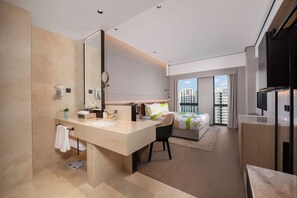 A modern hotel room with a large mirror, a sink, a chair, a bed, and a TV. - Holiday Inn Beijing Daxing Centre By Ihg (Daxing)