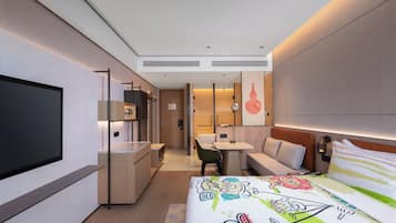 Une chambre d’hôtel moderne équipée d’un grand lit, d’un bureau, d’une chaise et d’un téléviseur.
