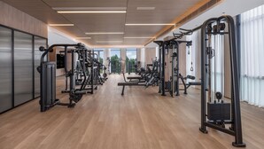 A modern gym with various exercise machines, large windows, and a wooden floor. - Holiday Inn Beijing Daxing Centre By Ihg (Daxing)