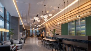 A modern bar area with a long counter, multiple bar stools, and pendant lighting. - Holiday Inn Beijing Daxing Centre By Ihg (Daxing)