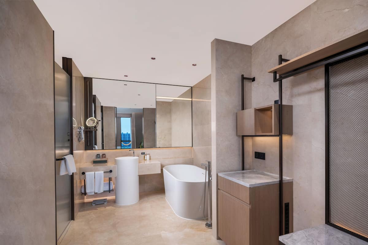 Un bany modern amb una banyera gran, una zona de dutxa separada i un lavabo amb mirall.