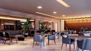Un restaurante moderno con paredes de ladrillo, mesas redondas y asientos cómodos.