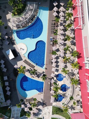 An aerial view of a resort with multiple swimming pools, sun loungers, and palm trees. - Sao Pedro Thermas Resort (São Pedro)