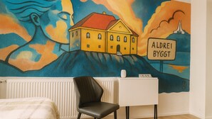 A room with a mural of a house and a sign reading "ALDEREI BYGGT". - Stykkisholmur Inn (Stykkisholmur)