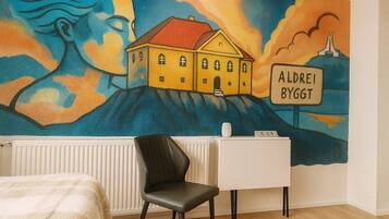 Ein Zimmer mit einem Wandgemälde eines Hauses und einem Schild mit der Aufschrift 'ALDEREI BYGGT'.