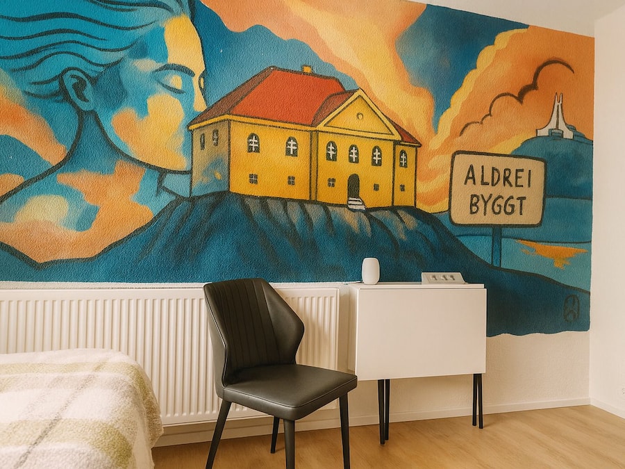 Quarto com um mural de uma casa e uma placa com a inscrição "ALDEREI BYGGT".