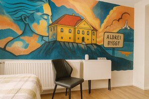 A room with a mural of a house and a sign reading "ALDEREI BYGGT". - Stykkisholmur Inn (Stykkisholmur)