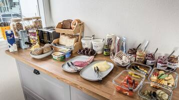Um buffet de café da manhã com diversos alimentos e acompanhamentos.