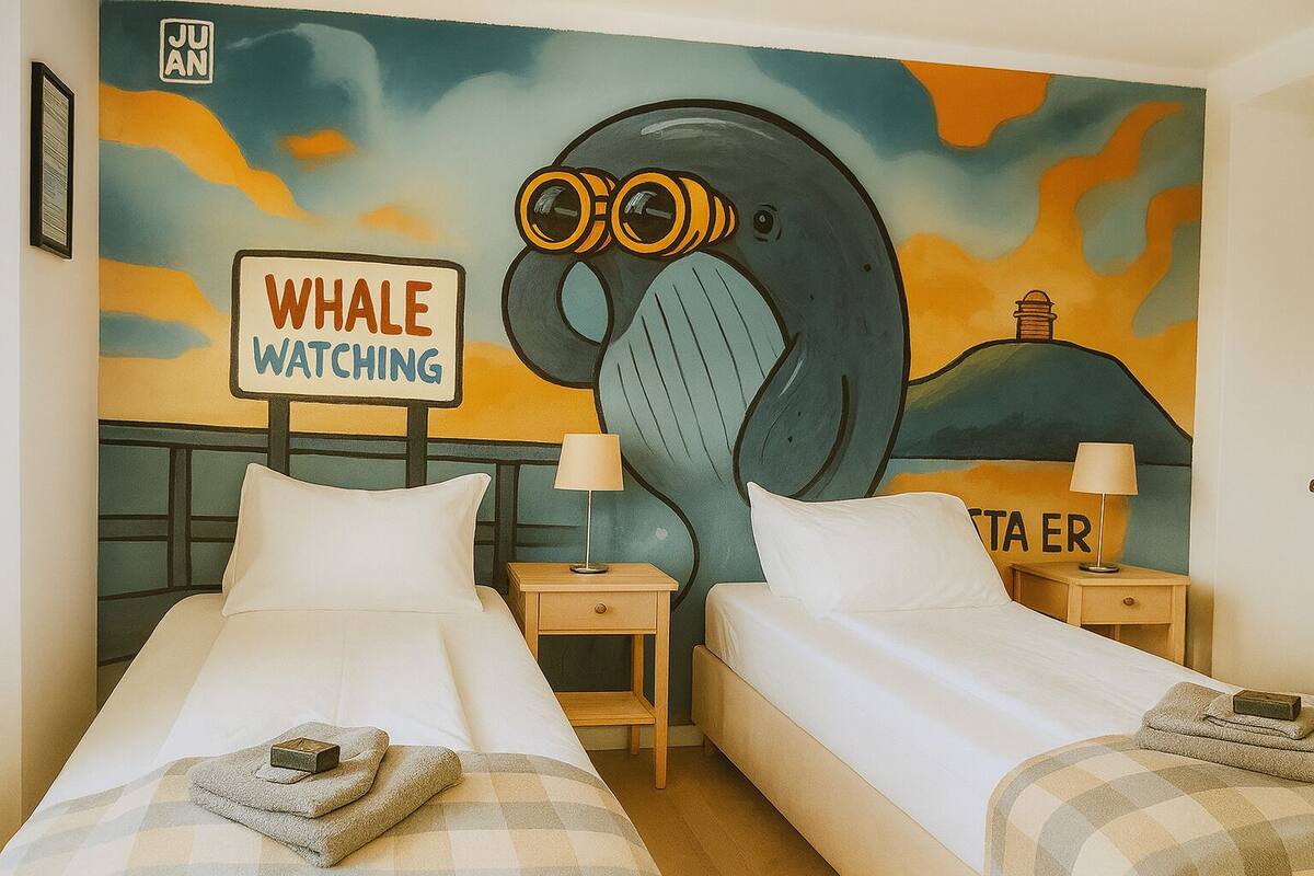 A hotel room with two beds, a mural of a whale, and a sign that reads "Whale Watching".