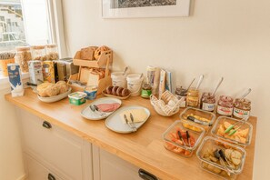 A breakfast buffet with various food items and condiments. - Stykkisholmur Inn (Stykkisholmur)