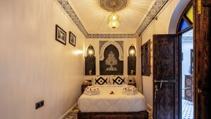 Quarto com uma cama grande, painéis decorativos na parede e piso estampado.