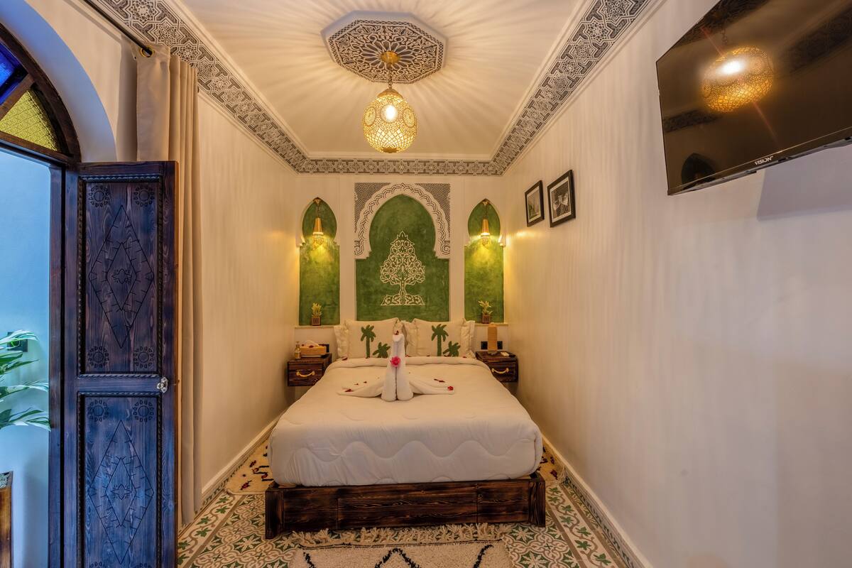 Una camera da letto con un letto grande, pannelli decorativi a parete e un lampadario.