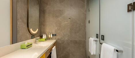 A modern bathroom with a double sink, a large mirror, and a glass shower enclosure.