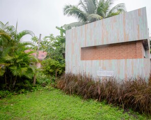 A building with a 'Only Car Parking' sign, surrounded by greenery and palm trees. - Koh Lanta Amantra Hostel - Women Only (Ko Lanta)