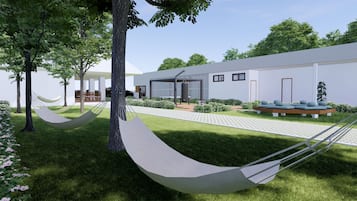 A modern building with a covered patio, a hammock, and a seating area with cushions.