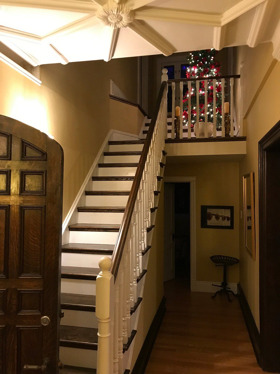 Eine Treppe mit weißer Brüstung und einer Holztür auf der linken Seite.