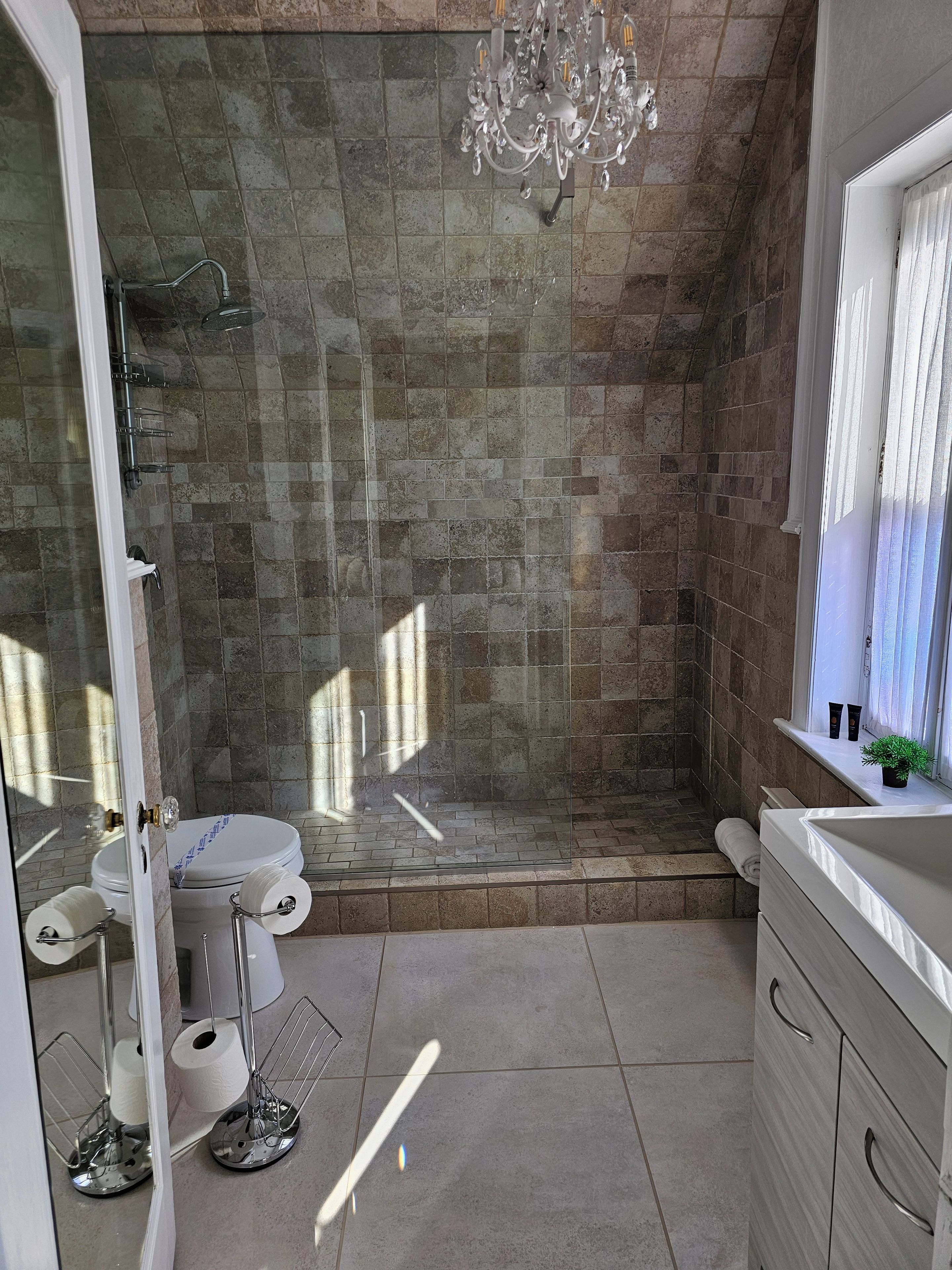 A bathroom with a shower, toilet, and sink.