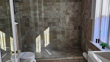 A bathroom with a shower, toilet, and sink.