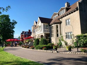 A row of historic buildings with a paved walkway and red umbrellas. - The Trinity Resort - Scenery (Pembroke)