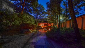 A traditional Japanese building with a stone pathway leading to a wooden structure. - Awara Onsen Minoya Taiheikaku (Awara)