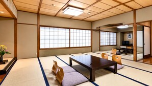 Ein traditioneller japanischer Raum mit Tatami-Böden, einem niedrigen Tisch und Stühlen.
