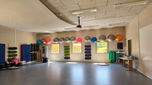 A spacious room with a high ceiling, padded mats, and exercise balls arranged against the walls. - Comfortable Danish Room for Duo Stays (Lemvig)