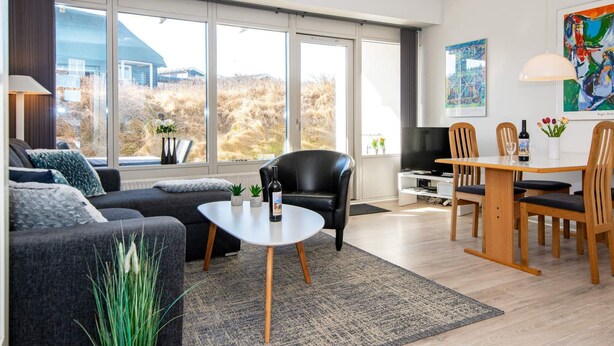 Ein modernes Wohnzimmer mit Sofa, Couchtisch und Essbereich.