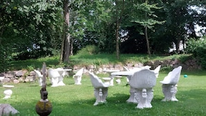 A garden with various white stone sculptures and a metal sculpture on a tripod. - 2-person Room in a Hotel in Tranekaer (Tranekaer)
