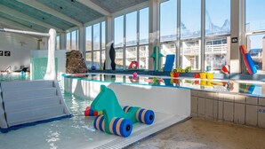 An indoor swimming pool with a glass barrier, a stone wall, and various colorful toys and equipment. - Apartment in Holiday Park- Shared Kitchen (Ulfborg)