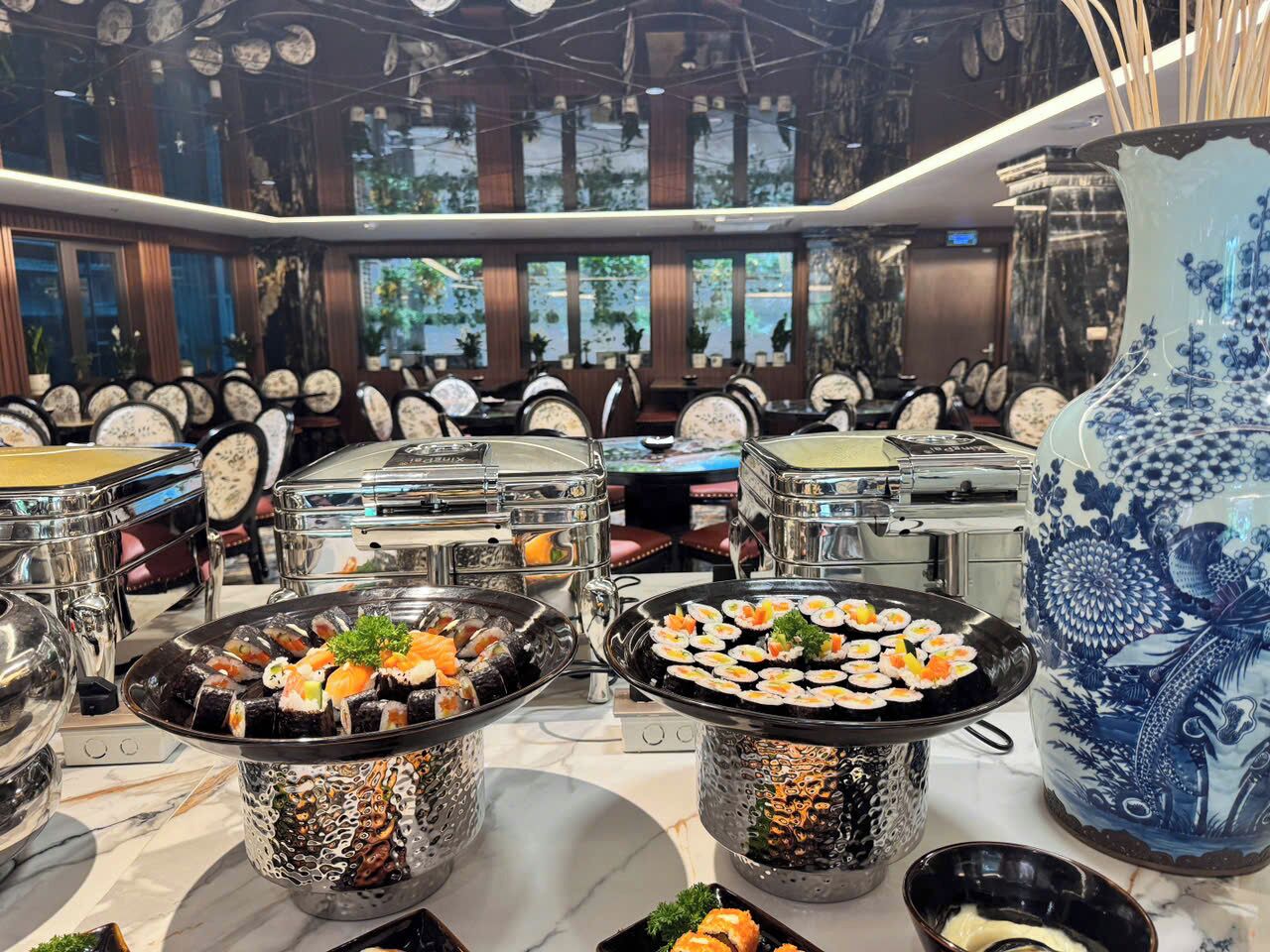 A restaurant with multiple tables, each with a variety of sushi dishes.