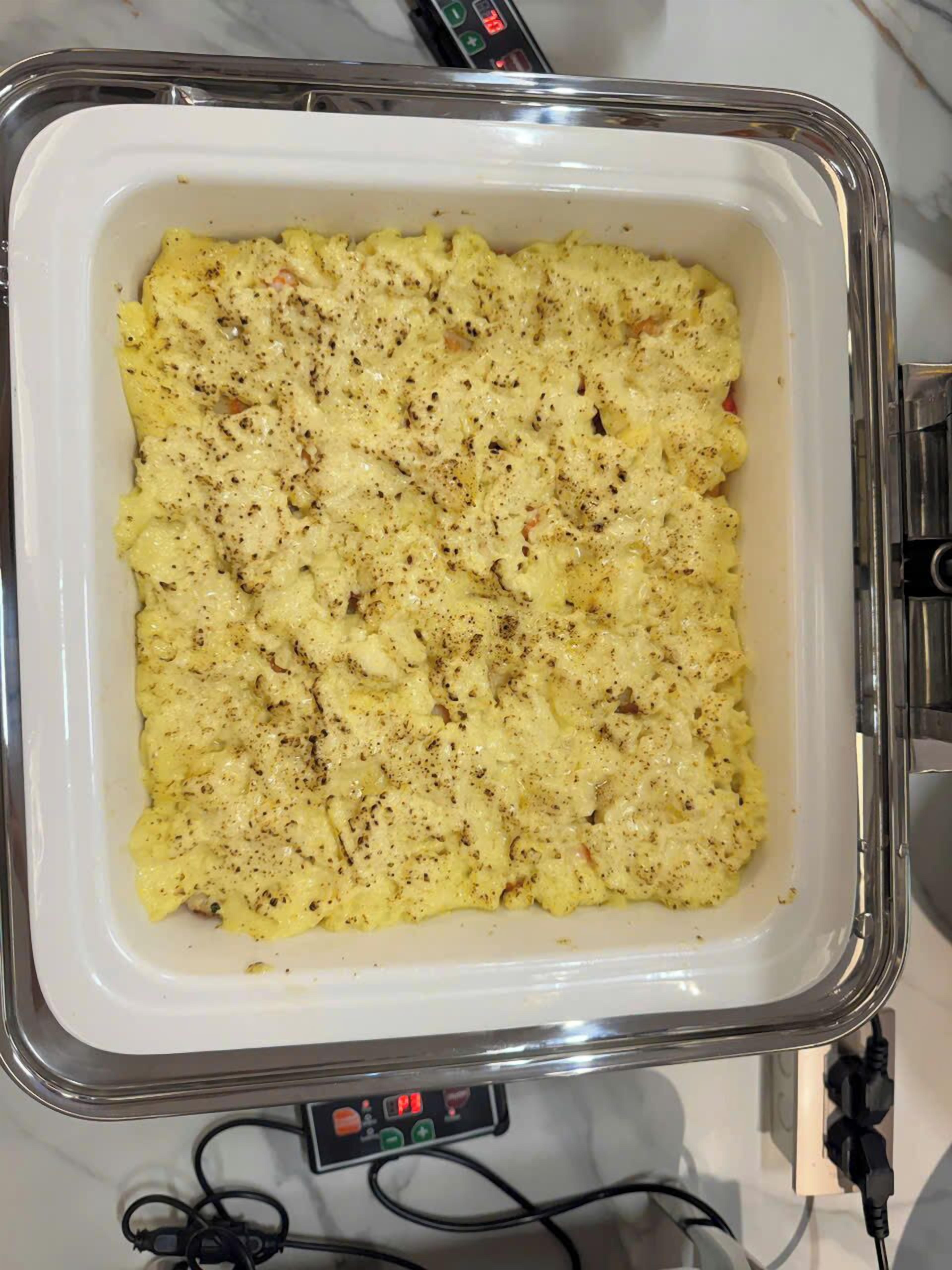 A rectangular glass baking dish with a creamy, seasoned dish inside, placed on a kitchen counter.